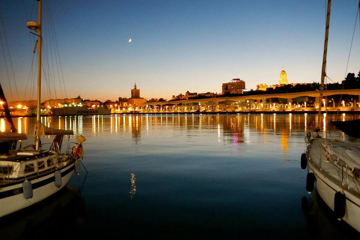 Bars and palm trees along the Muelle Uno promenade at Malaga port in the evening — 1